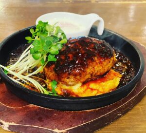 京都駅近くにある肉カフェ「NICK STOCK イオンモールKYOTO店」にて提供している甘辛い照り焼きソースにとろ～り温玉が絡みあう『温玉照り焼きハンバーグ』の写真