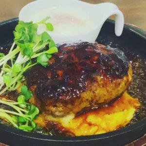 京都駅近くにある肉カフェ「NICK STOCK イオンモールKYOTO店」にて提供する温玉照り焼きハンバーグのイメージ写真